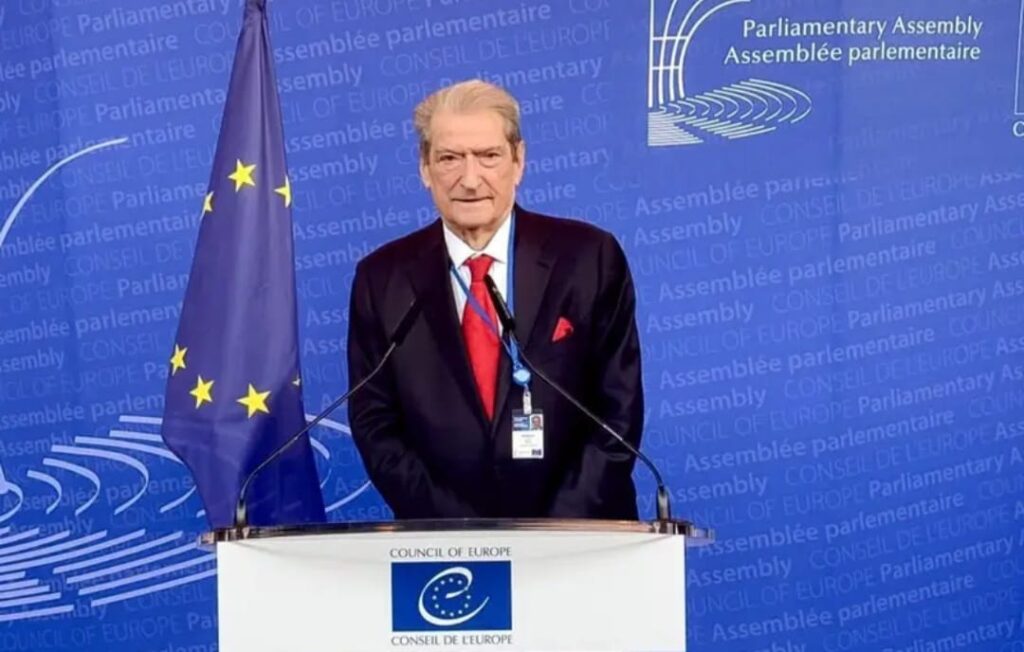 Sali Berisha bei einem Event in Straßburg, im Hintergrund EU‑Symbole.