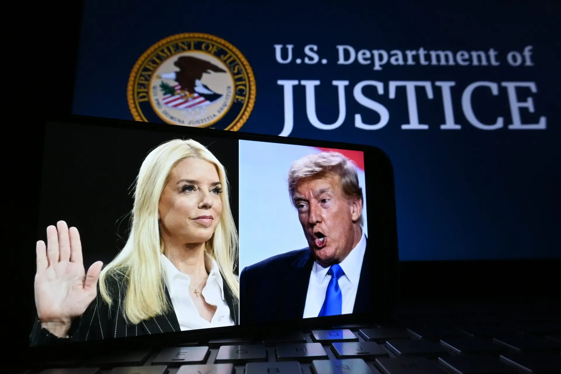 Photos of Pam Bondi and Donald Trump displayed on a smartphone screen, with the U.S. Department of Justice seal in the background.