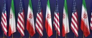 US and Iranian flags representing the US–Iran crisis, nuclear negotiations in Geneva, and the central role of deterrence.
