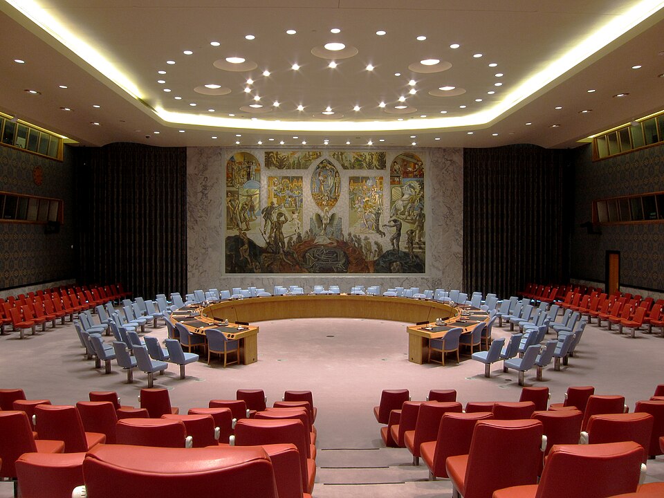 UN Security Council chamber in New York, showing delegates seated around the horseshoe‑shaped table during a meeting.